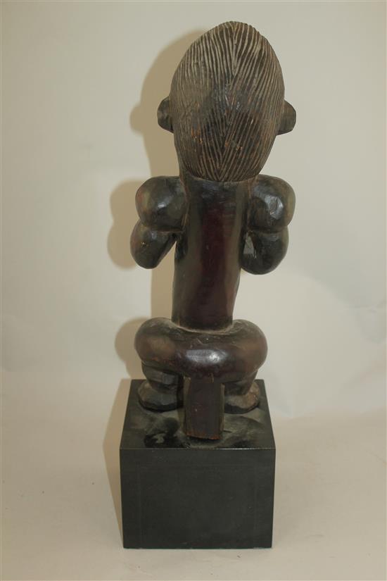 A West African carved hardwood figure of a seated male, overall 22in.